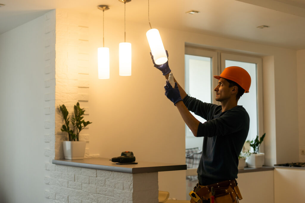 Electrician installs lamp lighting